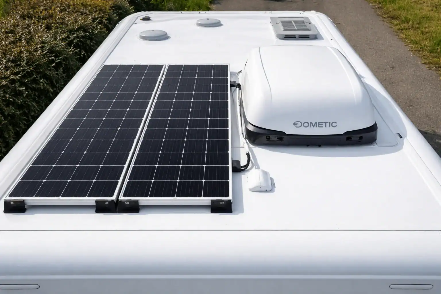 Zonnepanelen op camperdak naast een dakairco