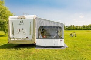 Fiamma Side W Pro zijwand met raam, gespannen tussen luifelarm en grond bij een camper