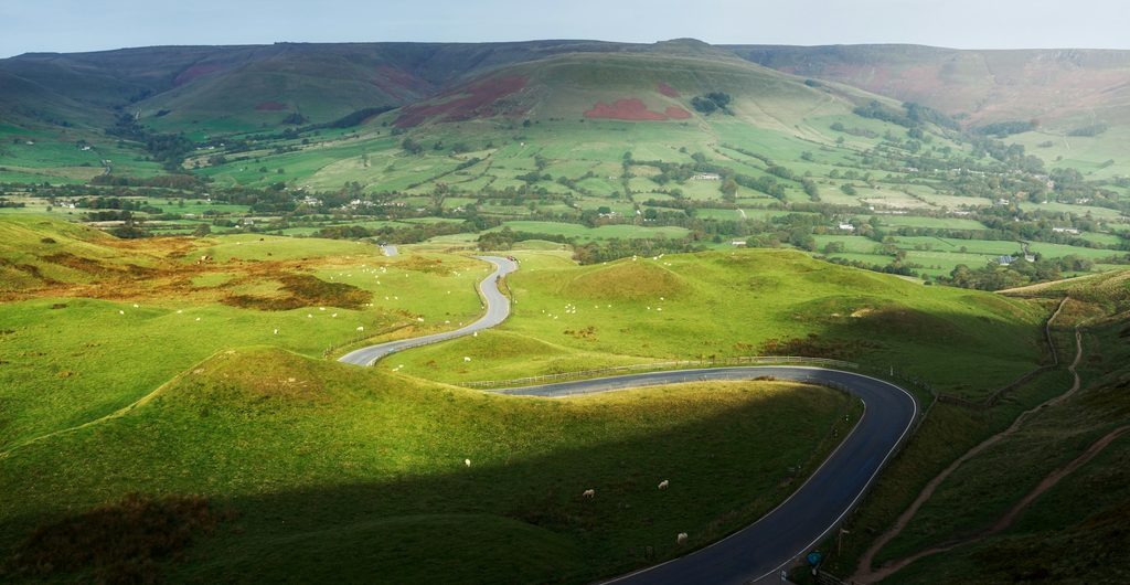 Smalle slingerweg door het groene dal bij Mam Tor in het Peak District
