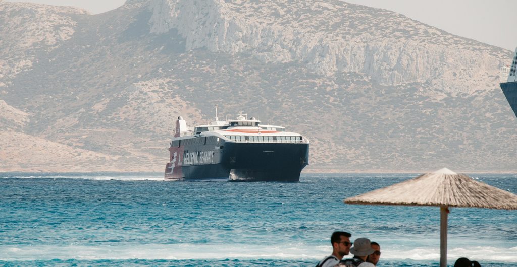 Snelle veerboot vaart langs de rotsige kust van Koufonisia in de Cycladen