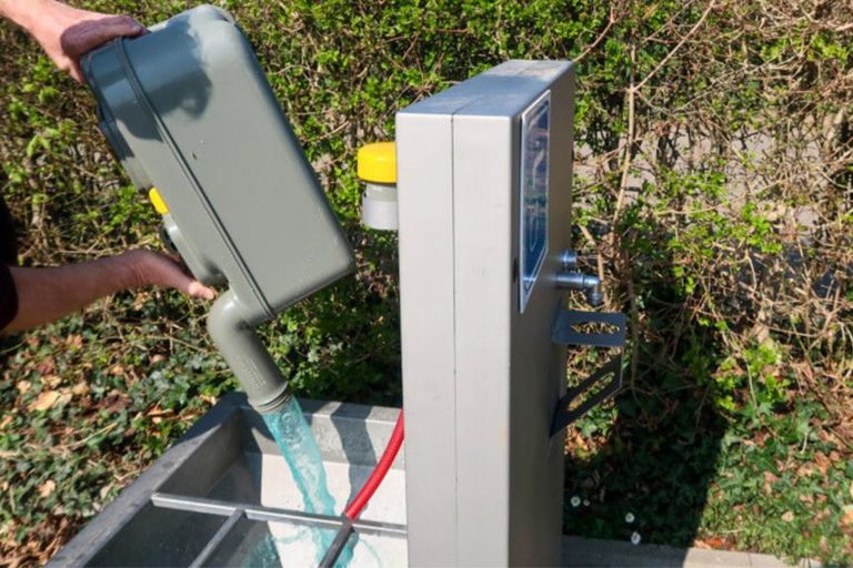 Chemisch toilet legen bij een lospunt: de cassette van een cassettetoilet wordt boven de rvs-bak van een servicepunt leeggegoten