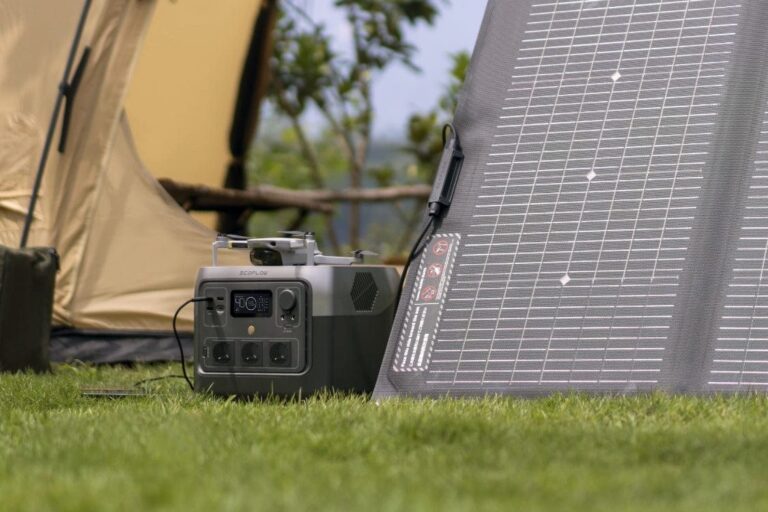Powerstation met zonnepaneel: EcoFlow River 2 Pro en een opgevouwen paneel op het gras voor een tent