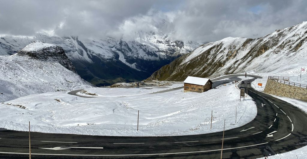 Sneeuwkettingen: haarspeldbocht op de Gro&szlig;glockner-Hochalpenstra&szlig;e met verse sneeuw langs de weg