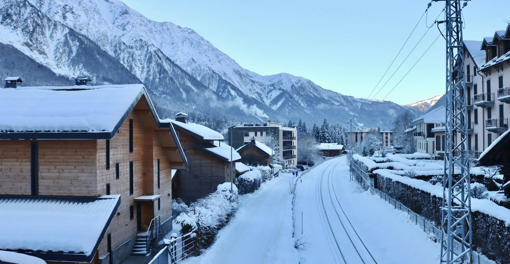 Winterbanden Frankrijk: Chamonix in de sneeuw, met besneeuwde chalets, het spoor en de bergen van het Mont Blanc-massief