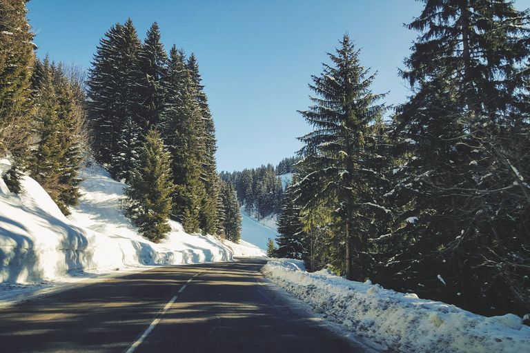 Winterbanden Frankrijk: bergweg naar Flaine in de Haute-Savoie, met sneeuwwallen en sparren langs de weg