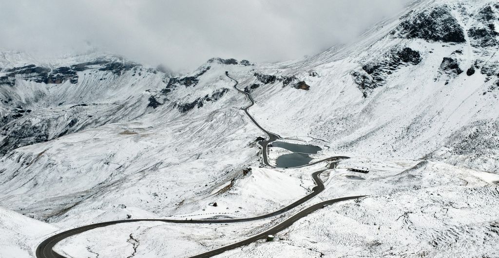 Winterbanden Oostenrijk: de Gro&szlig;glockner-Hochalpenstra&szlig;e met haarspeldbochten tussen besneeuwde bergen